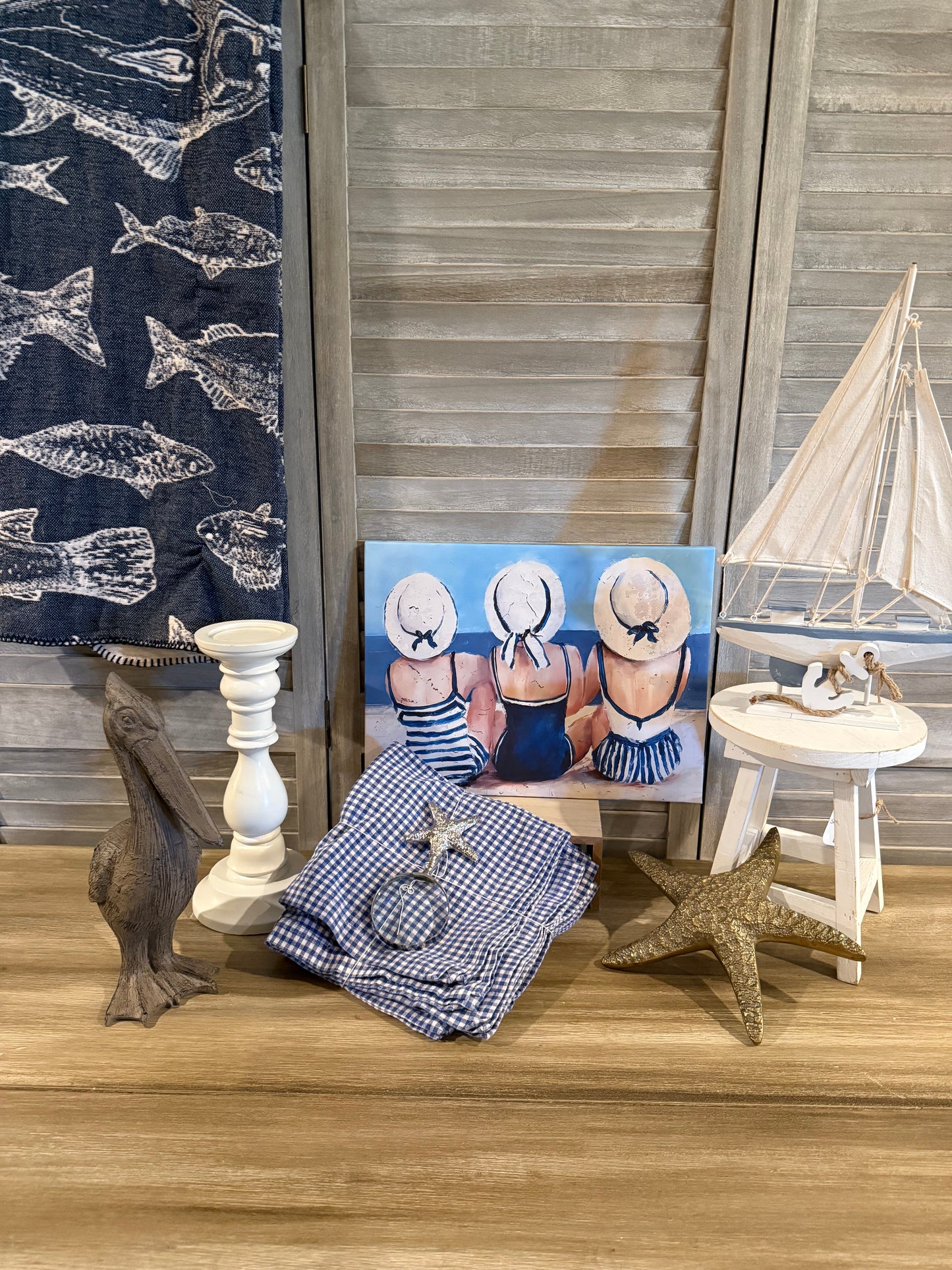 Coastal beach décor with nautical art, sailboat figurine, starfish accents, and blue gingham—perfect for summer or seaside home styling